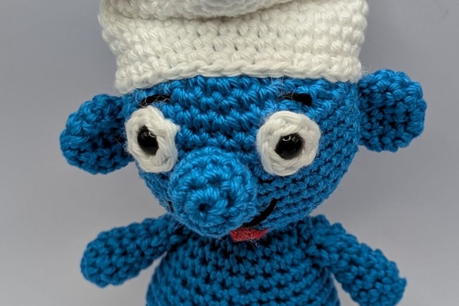 ein gehäkelter Schlumpf mit Baguette auf dem Kopf